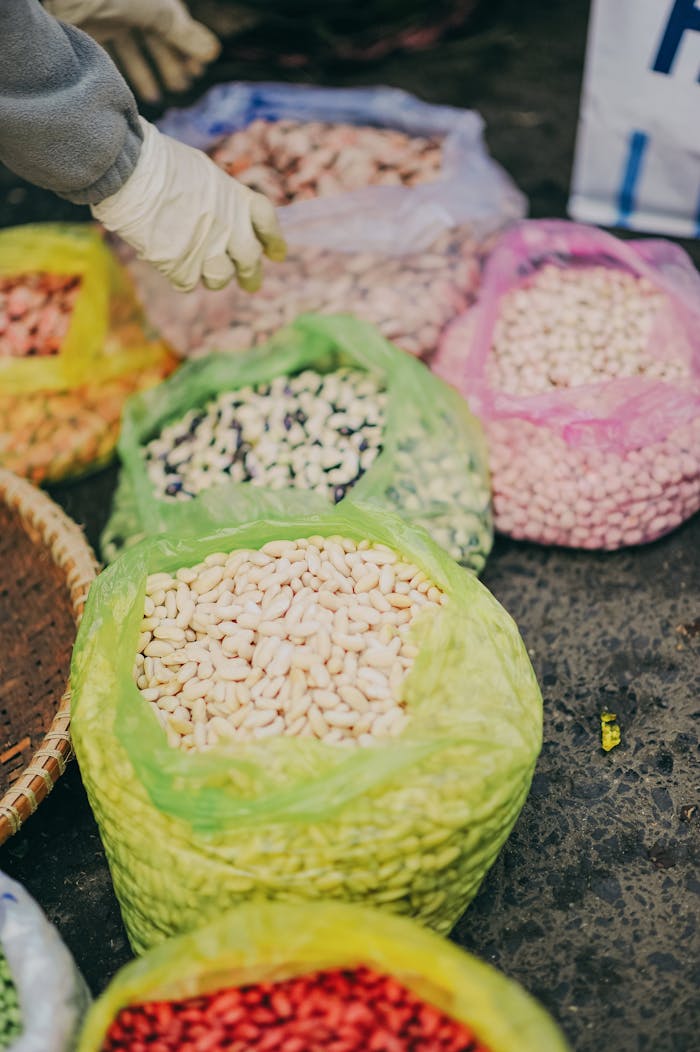 gallery-04 Colorful sacks of organic beans and legumes in a vibrant market setting.