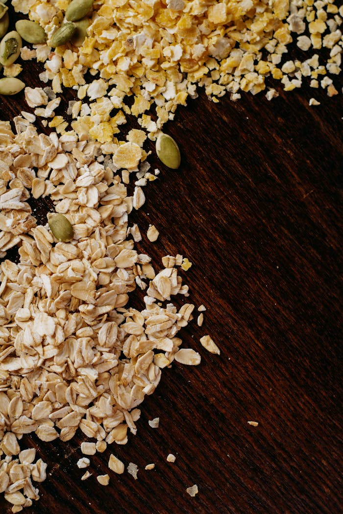 gallery-05 High-angle view of oats, cornmeal, and seeds on a dark wooden table. Perfect for healthy food themes.